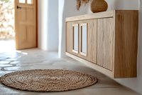 Modern minimalist interior with floating wooden cabinet and round jute rug on concrete floor. Natural light streaming through doorway creates warm atmosphere.