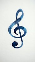 Treble clef symbol painted in watercolor shades of blue on white background, isolated and ready for music education, design projects, and creative compositions.