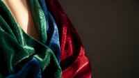 Luxurious velvet fabric in emerald green, navy blue, and burgundy red with rich texture and soft folds, suitable for fashion, textile, and design projects.