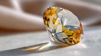 Sparkling yellow diamond gemstone with brilliant facets casting shadows on soft fabric background. Luxury jewelry concept.