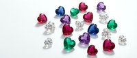 Collection of colorful precious gemstones including diamonds, rubies, emeralds, sapphires and amethysts scattered on white background for jewelry design.