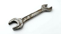 Old rusty wrench tool isolated on white background for repair maintenance and mechanical work projects.