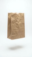 Crumpled kraft paper bag with handles isolated on white background, suitable for grocery, retail, and packaging design mockups.