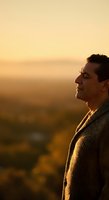 Adult male, South Asian ethnicity, wearing knit sweater, gazing at golden sunset landscape during golden hour. Contemplative mood suitable for wellness, mindfulness, and lifestyle concepts.