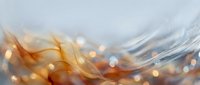 Abstract flowing waves with golden orange hues and bokeh light effects creating dynamic motion blur background for modern design projects.