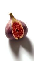 Fresh ripe fig cut in half showing red flesh and seeds isolated on white background for culinary and healthy eating designs.