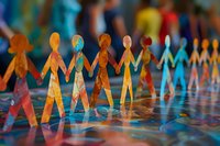 Colorful paper chain people holding hands in row symbolizing unity, diversity, teamwork and community support. Shallow depth artistic composition.