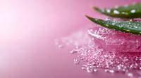 Fresh aloe vera leaf with water drops and pink sea salt crystals on pink background, macro photography for spa, wellness and skincare products.