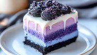 Layered purple ombre cheesecake slice with white chocolate drip, crushed chocolate cookies and sprinkles on white plate. Decadent dessert photography.