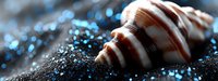 Striped seashell on dark sand with sparkling blue bokeh lights creating magical beach atmosphere. Macro photography with selective focus and blur effect.