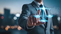 Professional businessman touching digital justice scales with glowing network connections representing legal technology and digital law services.