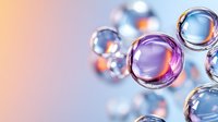 Transparent glass spheres with purple and orange reflections floating on blurred pastel background, macro photography with soft bokeh effect for creative design.