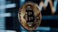Golden bitcoin cryptocurrency coin against blurred trading chart background showing market volatility and digital currency trends.