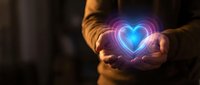 Hands cupping glowing neon heart with purple and blue light effects against dark background for love, care, and emotional wellness concepts.