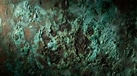 Weathered copper surface with green patina oxidation texture showing natural aging process and corrosion patterns on metal background.