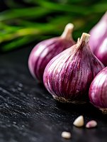 Fresh purple garlic bulbs arranged on dark wooden background with selective focus, dramatic lighting highlights texture and natural vibrant color. Food photography.