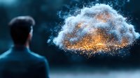 Businessman facing glowing cloud of golden particles and white smoke against dark background, representing digital transformation and cloud computing technology.