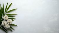 Fresh green palm leaves and white hydrangea flowers arranged in corner composition on light gray background with copy space for text or design.