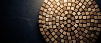 Wooden mosaic circular pattern with geometric squares arranged in concentric rings on dark background for interior design and decorative projects.