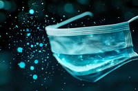 Medical face mask with glowing turquoise particles floating in dark background, concept of virus protection and healthcare safety in modern medicine.