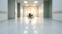 Empty wheelchair in bright modern hospital corridor with green walls and polished floors for healthcare and medical facility concepts.