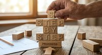 Senior businessman hands arranging wooden blocks spelling step by step progress concept for business planning and goal achievement strategy.
