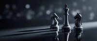 Black chess pieces king knight and bishop standing on reflective surface with dramatic lighting and bokeh background for strategy concepts.