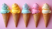 Colorful ice cream cones in pastel colors with sprinkles arranged in row on pink background. Sweet frozen dessert variety with waffle cones showing mint, yellow, pink flavors.