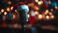 Vintage microphone wearing red Santa hat against blurred Christmas lights background creating festive holiday atmosphere for seasonal entertainment and music.