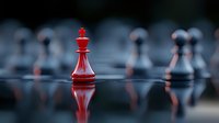 Red chess king piece standing out among blurred black pawns on reflective surface, dramatic lighting creates leadership and strategy concept.