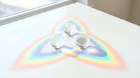 Three crystal glass balls refracting light into a vibrant rainbow spectrum on a white surface, creating a stunning triangular prism effect.