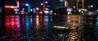 Empty bullet casing on wet asphalt street with blurred neon city lights reflecting on pavement at night, urban crime scene concept.