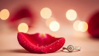 Red lips and diamond engagement ring with romantic bokeh lights background for Valentine's Day celebration and wedding proposal concepts.