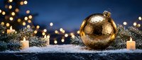 Golden bauble with tinsel and candles on snowy surface against blue bokeh background, suitable for holiday greeting cards and festive season marketing materials.