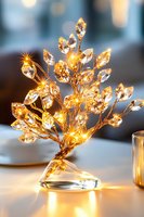 Illuminated crystal tree decoration with warm LED lights creating magical glow on white surface, elegant holiday table centerpiece for festive events.