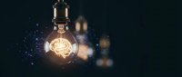 Glowing light bulb with brain filament symbolizing innovation, creativity and bright ideas against dark background with bokeh lights for business concepts.