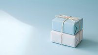 Two stacked gift boxes wrapped in light blue and white paper tied with twine on a soft blue background with copy space.