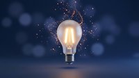 Glowing incandescent light bulb with golden sparks and particles exploding from top against dark blue bokeh background, representing innovation, creativity, and bright ideas for business and technology concepts.