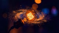 Glowing incandescent bulb exploding with golden sparks and light particles against dark background, representing energy, innovation, and creative ideas for design projects.