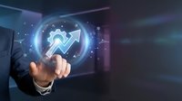 Businessman in dark suit touching glowing upward arrow icon with digital interface, representing growth, success, and financial progress in modern business technology environment.