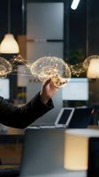 Hand holding glowing brain with neural network connections in modern office workspace representing artificial intelligence and innovation concepts.