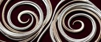Elegant metallic silver spiral swirls on dark burgundy background creating luxurious decorative pattern for premium design projects and artistic applications.