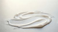 White cream swirl texture on neutral background for skincare cosmetic product design and beauty advertising applications.