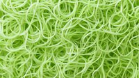 Fresh green spiralized zucchini noodles creating healthy low-carb pasta alternative background pattern, raw vegetable spirals in close-up view.