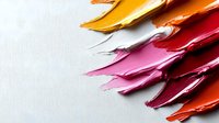 Vibrant paint smears in warm tones from yellow to red create dynamic diagonal strokes on white background, showing rich texture and glossy finish. Isolated for creative design use.