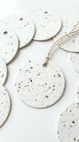 Isolated round seed paper ornaments with natural fiber twine on white background, ready for eco-friendly gift tags, sustainable packaging design, and environmentally conscious craft projects.