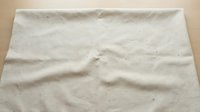 Natural linen fabric texture with wrinkles and creases on wooden surface. Organic cotton material background for eco-friendly design projects and crafts.