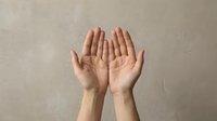 Open hands reaching upward in prayer or receiving gesture against neutral background for spiritual and wellness concepts.