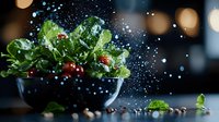 Fresh green salad with cherry tomatoes in dark bowl against blurred background with water drops and dramatic lighting for food photography and menu design.