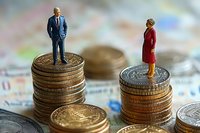 Miniature businessman and businesswoman standing on unequal coin stacks, representing gender pay gap and wage inequality in workplace compensation.